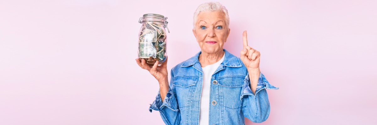 Hip grandma in jean jacket holding a jar of money